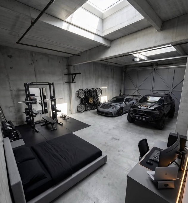The image shows a large room with a bed, two cars parked inside, and a desk with a computer setup. The room has a concrete floor and white walls, giving it an industrial feel. There are also some exercise equipment pieces visible in the room. A laptop is placed on the desk next to the computer setup, while a keyboard can be seen nearby. 

The post features a list of words that seem unrelated to the image's content: "2026 will make millionaires Like if you agree! #sol #memecoin #100x". The post seems to be promoting an idea or concept related to the room and its contents, but it does not directly connect with the actual scene.