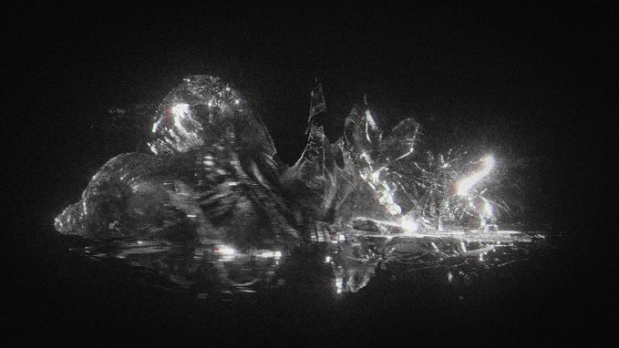 An abstract black and white digital artwork shows a crystalline or liquid-like form with bright reflective highlights against a dark background, appearing to sit on a reflective surface.