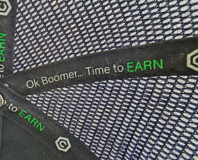 Close-up of mesh athletic apparel with a tag reading 'Ok Boomer... Time to EARN'.