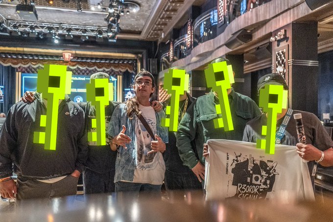 A group of six men pose together inside what appears to be an upscale venue or bar at NFT NYC, with four of their faces obscured by bright green question mark graphics, while the center man smiles and gives a peace sign wearing a denim jacket over a graphic tee, and the others display merchandise including a white shirt reading "RSORDER ORIGINAL" and "OPUS TOGETHER." The post references this as an IRL meetup with "ALPHA KEY HOLDERS (5+ keys)" during NFT NYC, though the image visually masks the identities with question marks, creating a playful contrast between the caption's claim of an honor-filled gathering and the censored, anonymous presentation of the group's faces.