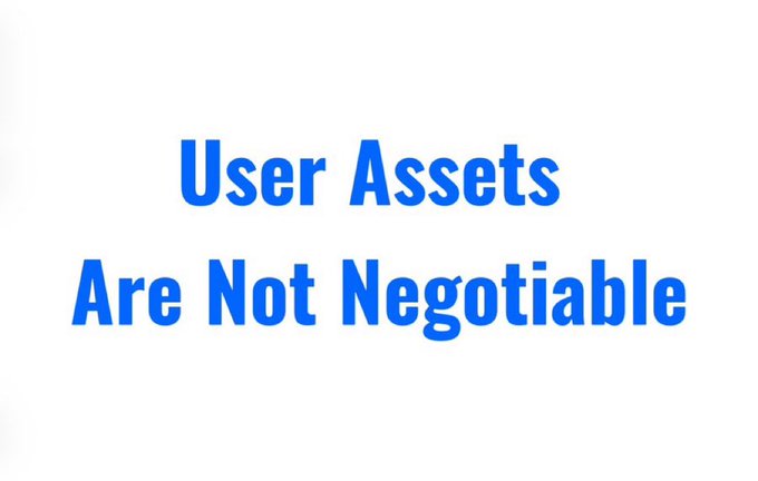 The image features a white sign with blue text that reads "User Assets Are Not Negotiable" written in black letters. The sign is placed against a gray background, making it stand out prominently. This message serves as a reminder for users to have control over their own assets and not rely on centralized authorities or institutions when it comes to managing their finances.