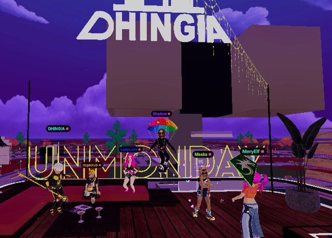 A virtual reality scene showing avatars dancing under neon signs reading 'DHINGIA' and 'UNIMINDIA' at an event with a large geometric structure in the background.