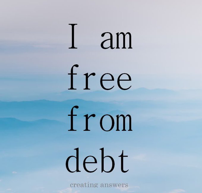 An inspirational graphic with black text reading 'I am free from debt' over a hazy blue mountain landscape, with 'creating answers' at the bottom.