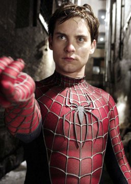 A young man in a red and black Spider-Man suit points toward the camera in an alleyway setting, representing Tobey Maguire's iconic portrayal of the web-slinger referenced in the post about his 90% odds of returning in Avengers: Doomsday.