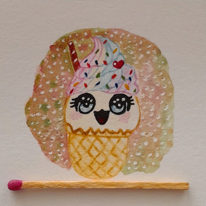 A watercolor painting of a cute ice cream cone character with big eyes and a face, topped with colorful sprinkles, with a physical matchstick placed below it.
