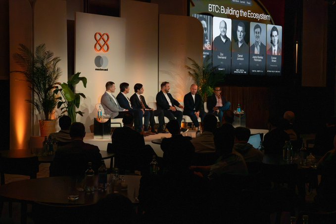 A panel discussion at the Token2049 event titled 'BTC: Building the Ecosystem' featuring speakers Zac Townsend, David Johnson, Andre Serrano, and Tomas.
