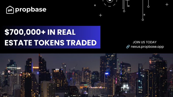 The image shows a vibrant cityscape at night with numerous tall buildings illuminated by bright lights against a dark sky. The text overlay displays a promotional message for Propbase, indicating that they have achieved $700,000+ worth of real estate tokens trading on their P2P marketplace and highlighting the significant participation from users in today's post.
