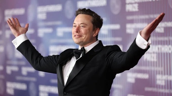 The image features a man wearing a tuxedo with his arms raised in the air while standing against a purple background that includes text from a poster announcing an award, the name of the company being KALSHI, and the price for bitcoins. The main focus is on the man's body language, specifically his arms spread wide open as if he is celebrating or expressing excitement about something. This could possibly be related to an announcement of some sort in the image that ties into the broader theme of bitcoin mining and technology appreciation.
