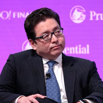 The image features a man wearing a suit sitting at a table, possibly attending a financial conference or event. The person is seated in front of purple text, which seems to be part of a presentation or announcement about Bitcoin mining, as indicated by the "BITMINE" words present on the background. The Bitcoin mining price was mentioned to be $2,003 per eth. The man appears to be interested in the content being discussed and may have questions or concerns related to this particular topic.