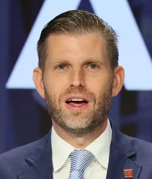 Eric Trump, pictured during an interview, is featured in a post highlighting American Bitcoin's strong Q2 performance, including the addition of 11,300 miners, a 12% hashrate increase to 28 EH/s, and holdings of 8,000 BTC valued at $501 million with steady gross margins near 50%.