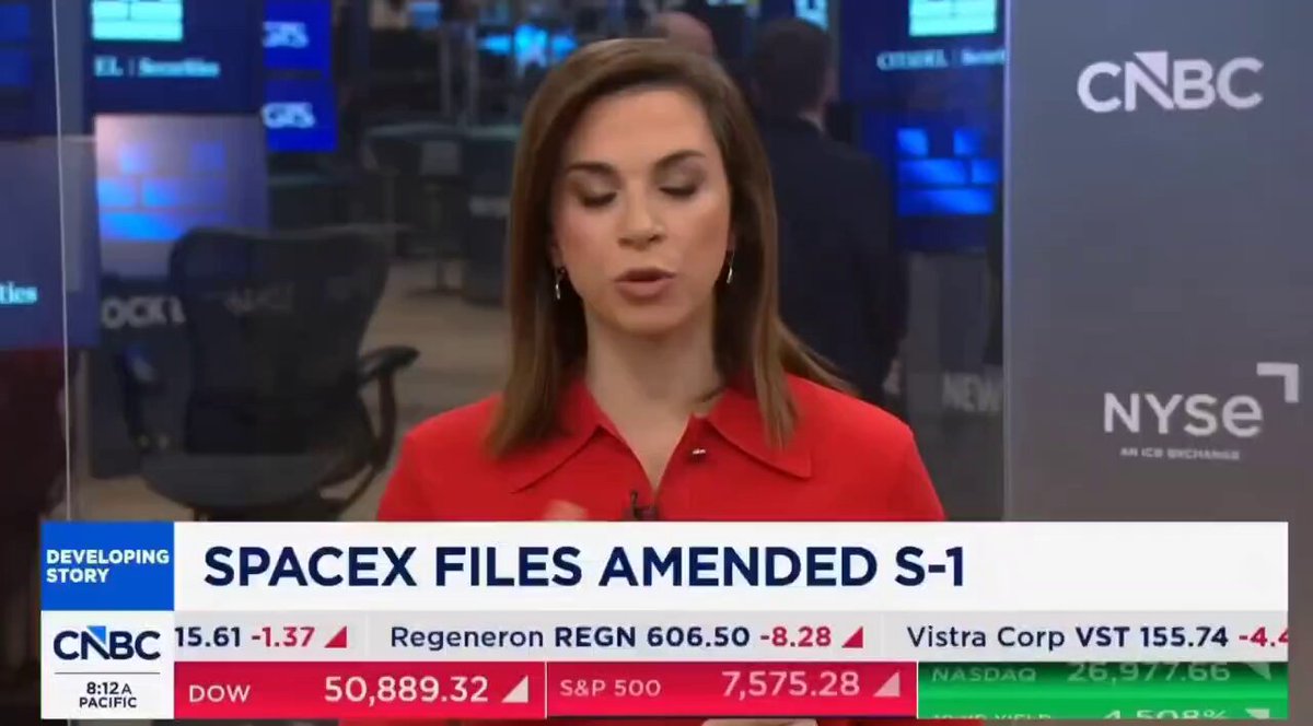 The image shows a person talking on TV, presumably discussing news related to a recent space company's IPO or some other topic involving the SpaceX company. The background of the video contains various monitors, likely representing different aspects of the news story being discussed. The title of the report is "BREAKING: CNBC REPORTS ELON MUSK'S $2 TRILLION SPACEX IPO COULD ARRIVE WITHIN DAYS. THE COMPANY IS SAID TO HOLD 18,000 BITCOIN ON ITS BLUE BUDGET sheet." This information suggests that the story could be related to a space company's stock performance and its potential impact on investors' portfolios.