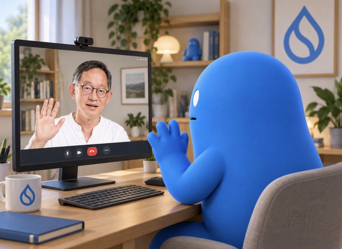 A blue 3D character sits at a desk waving at a man on a monitor during a video call, with a "Sui" logo water drop visible on a mug and wall art.