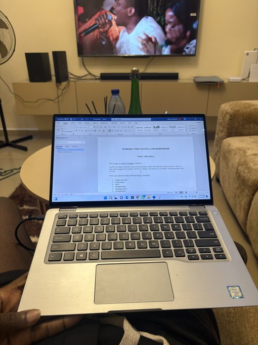 A person holds a Dell laptop displaying a Microsoft Word document titled "INTRODUCTION TO NFTS AND ROBINHOOD" in a living room with a TV playing in the background. The document's introduction page outlines what's coming next, aligning with the post about today's NFT and Robinhood introduction.