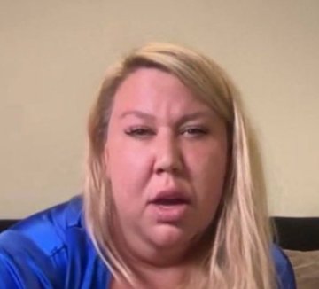 A blonde woman in a blue top is captured mid-speech in a close-up shot, appearing to be in the middle of sharing her opinion. The image appears to be a still from a video commentary, likely related to the social media post comparing memecoin to rainbet by user TIER1HATER.