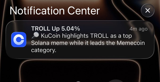 iPhone notification center showing an alert from KuCoin that reads 'TROLL Up 5.04%' with the message 'KuCoin highlights TROLL as a top Solana meme while it leads the Memecoin category.'