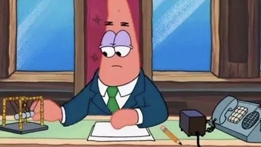 An animated cartoon character of Patrick Star dressed in a blue business suit and green tie, sitting at a desk with a Newton's cradle, paper, pencil, and telephone.