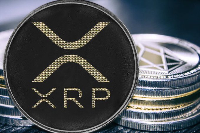 A close-up of a black XRP coin with gold lettering reading "XRP" displayed alongside stacked silver coins, symbolizing the cryptocurrency featured in the breaking news about #XRPL payment volume spiking to over one billion XRP before sharply declining by 90%.