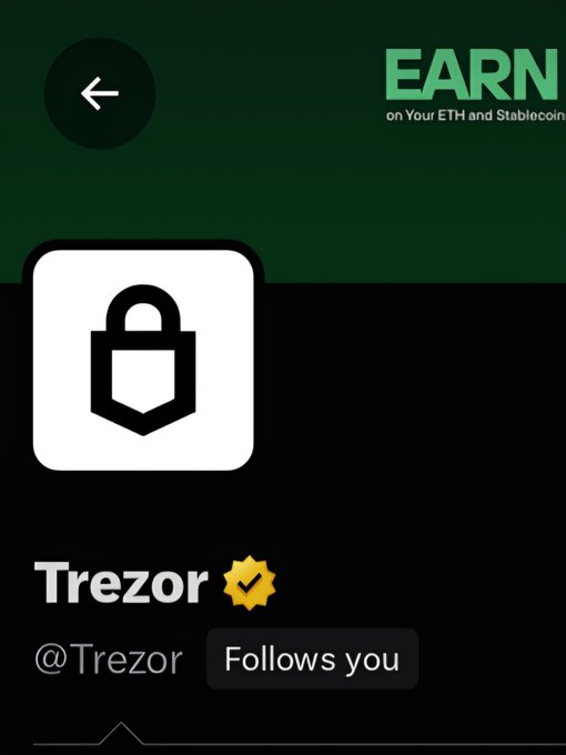 A profile screen showing the Trezor account (@Trazor) with a lock icon, a yellow verified checkmark, and a 'Follows you' button, against a dark green background with partial 'EARN' text.
