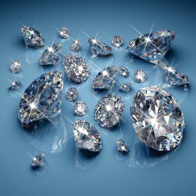 A collection of sparkling, multi-faceted diamonds displayed against a blue background.