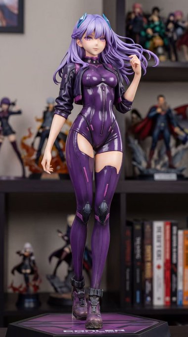 A purple anime figurine of a long-haired female character in a glossy futuristic bodysuit is displayed on a shelf, with text "DONUT MEDIA" visible on the base, serving as a preview of an upcoming DonutAI merchandise piece teased in the post.