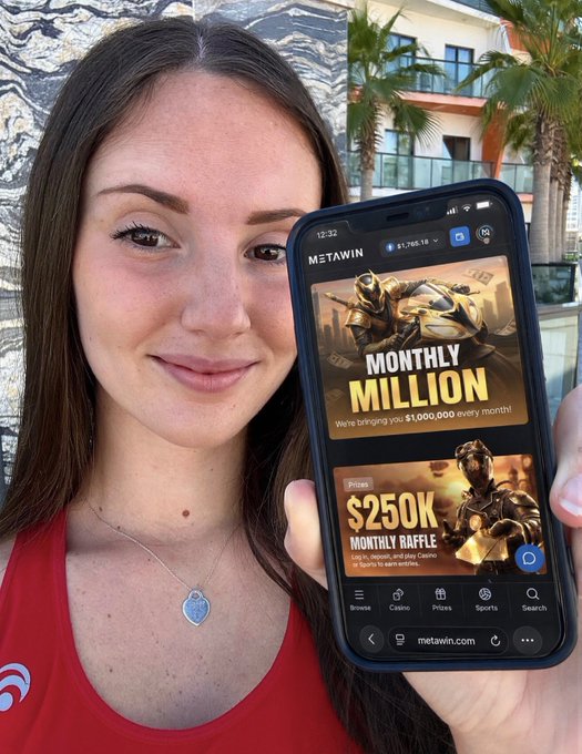 A young woman in a red tank top holds up her smartphone displaying the MetaWin betting site, which advertises a 'MONTHLY $1,000,000' giveaway and a '$250K MONTHLY RAFFLE'.