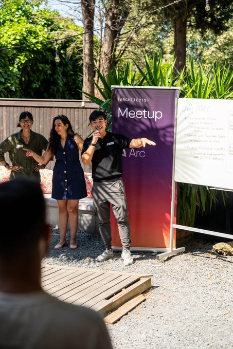 Two Arc representatives speak to an audience at an outdoor "Arc Meetup" event, with a man in a black t-shirt and a woman in a blue dress addressing attendees beside a "Meetup Arc" banner and a whiteboard.

The image captures the on-the-ground community engagement mentioned in the post, showing the DevRel team hosting a developer meetup in Türkiye to share their work with Arc.