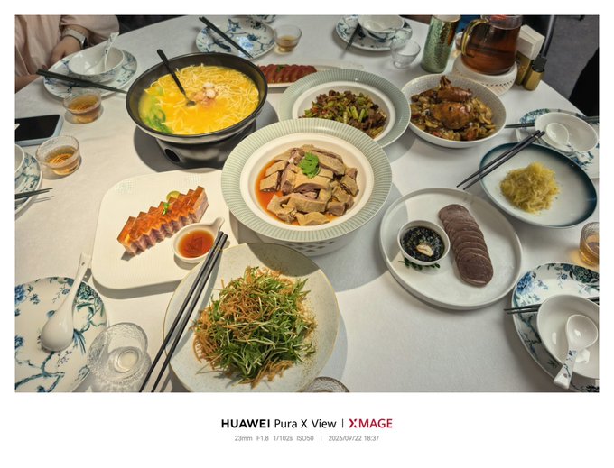 A photograph of a Chinese meal on a round table featuring multiple dishes including soup, chicken, and vegetables, watermarked 'HUAWEI Pura X View | XMAGE 23mm F1.8 1/102s ISO50 2026/09/22 18:37'.