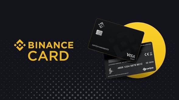 A promotional image for the Binance Card displays a black Visa debit card with 'SATOSHI NAKAMOTO' printed on it against a yellow and black background.