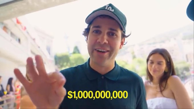 A man wearing a green LA Dodgers cap holds up three fingers, with the text '$1,000,000,000' displayed in yellow, while a woman stands in the background.