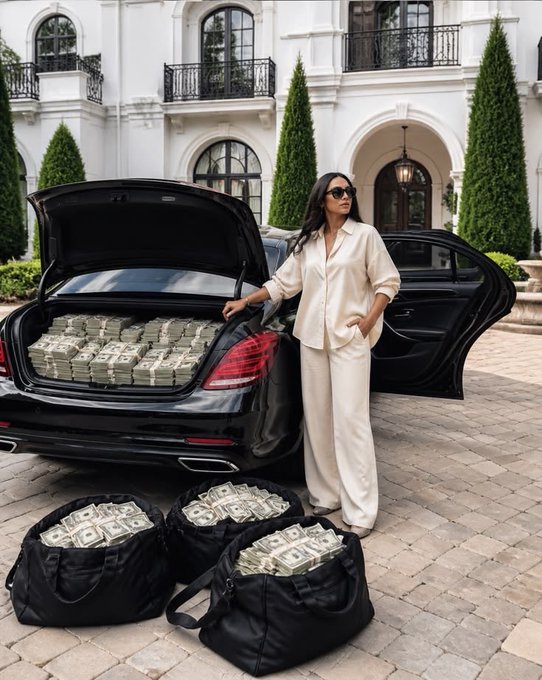A woman in a chic cream silk outfit and sunglasses stands confidently beside a black luxury sedan with its trunk and door open, revealing stacks of cash inside, while three black duffel bags overflowing with bundles of money sit at her feet on the driveway of a grand mansion. The image embodies the post's message of financial abundance and a luxurious new chapter, visually depicting the "rich era" with symbols of wealth, status, and carefree success.