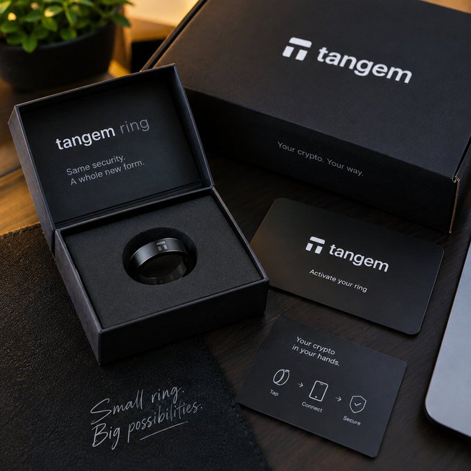 A product photo of the Tangem Ring in its black presentation box alongside its packaging, activation cards, and a 'Small ring. Big possibilities.' branded surface.