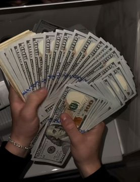 A pair of hands fans out a thick stack of $100 bills, displaying Benjamin Franklin's portrait and "100" markings on each note, visually emphasizing the massive $2 million profit described in the caption. The cash represents the trader's earnings from betting NO on Polymarket contracts that predicted crypto price pumps for ETH, BTC, SOL, and XRP, capitalizing on the low 1-3 cent risk to pocket near-certain payouts.