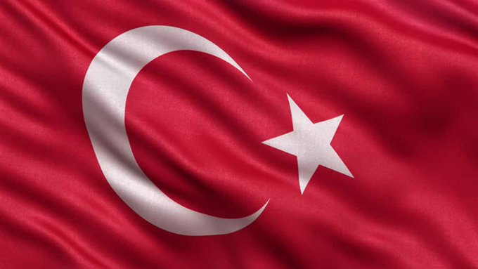 A close-up view of the flag of Turkey, featuring its distinctive white crescent and star on a red background.