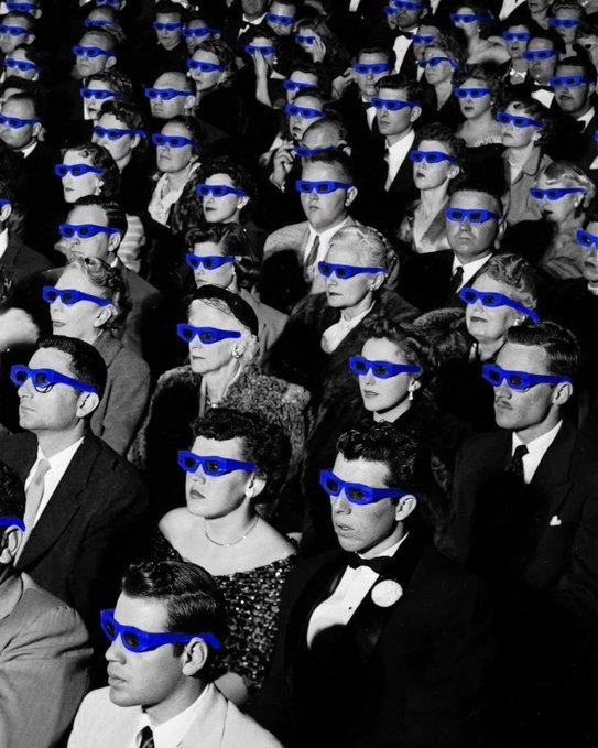 A black-and-white photo of a vintage movie theater audience wearing bright blue 3D glasses, captioned "all eyes are on @base," tying the nostalgic 3D viewing experience to Base's focus. The pop of blue eyewear against the monochrome crowd visually echoes the brand's signature color.