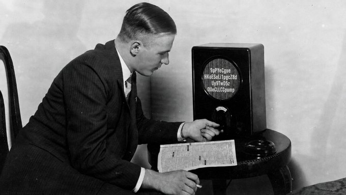 A vintage black-and-white photo shows a man in a suit adjusting the dial on an early television set, with what appears to be cryptographic or coded text displayed on the circular screen. The accompanying post humorously references this old image to suggest a "leaked" announcement about a pre-Bitcoin cryptocurrency, playing on the retro technology as visual proof of the coin's supposed ancient origins.