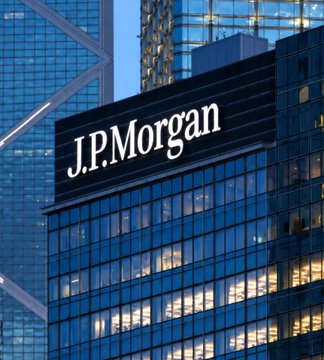 A photograph of a glass office building with a large black sign displaying the white text 'J.P.Morgan'.