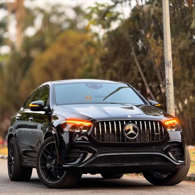 A black Mercedes-Benz SUV (appears to be an EQE SUV) parked on a street, shown from the front with headlights on.