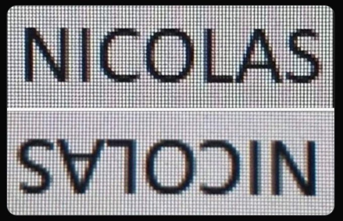 Text displayed on a digital screen reading 'NICOLAS' normally and 'NICOLAS' mirrored/reversed upside-down below it.