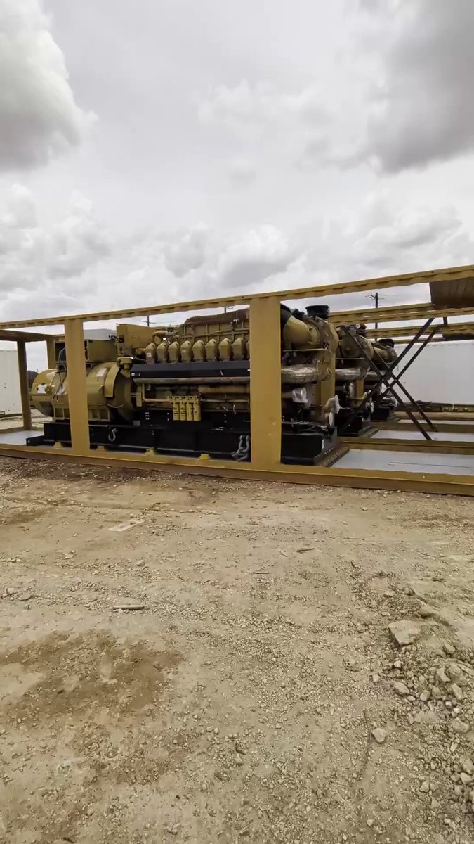 The image shows a large piece of industrial equipment, possibly an oil rig or power plant, sitting on a dirt field with a cloudy sky above. The equipment appears to be stationary, as indicated by the caption "Just about ready to roll...". This suggests that the machinery is currently not in use and could potentially be awaiting its next task or project.