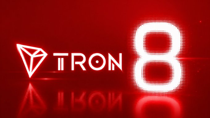 The image features a red background with white text that reads "TRON 8" written in capital letters, surrounded by neon lights. The text stands out against the red backdrop, making it easy to read and understand. The neon lights create a vibrant and eye-catching effect, drawing attention to the message displayed on the image.