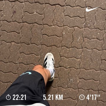 A first-person view of a person's legs and running shoes on a brick pavement, with Nike+ run stats showing 22:21, 5.21 KM, and 4'17" pace.