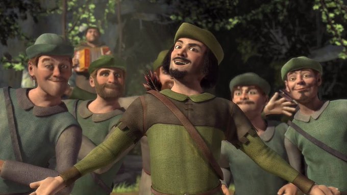 A 3D-animated scene shows a group of medieval men in green tunics and caps, with the central bearded figure wearing a feather in his hat and a brown sash, looking upward joyfully as his companions surround him in a forest setting.