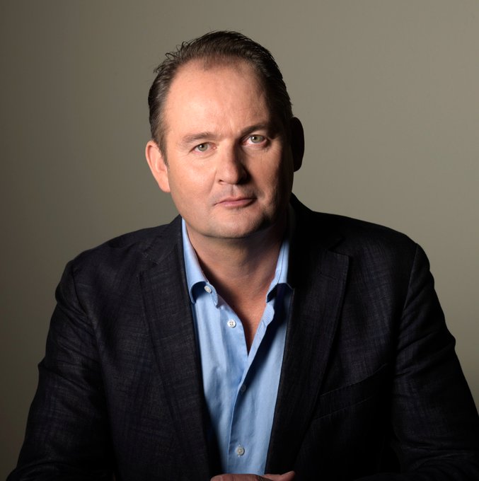 A man in a dark blazer and blue shirt sits against a neutral backdrop, matching the accompanying post identifying him as Willem Middelkoop, founder of the €200 million Commodity Discovery Fund, who reiterates his long-term Bitcoin price target of $1 million before 2030.