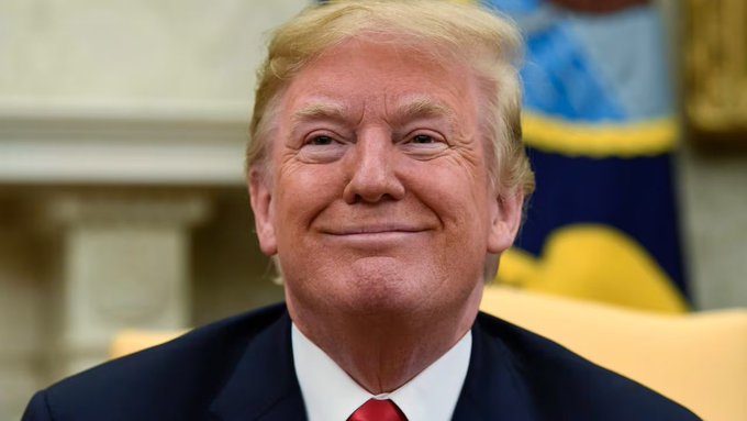 The image shows a man wearing a suit, tie, and smiling at the camera. He appears to be sitting down or standing next to an American flag. The caption reads "BREAKING: President Trump just said Bitcoin is the new oil." This statement seems to be related to the ongoing conversation about Bitcoin's potential impact on traditional financial systems.

The man in the suit, tie, and smile represents a political figure who has made a controversial statement regarding Bitcoin. His presence in front of an American flag adds context to his words, suggesting that he might be addressing the nation or discussing economic matters. The image captures this moment as the man looks directly at the camera with a serious expression on his face.