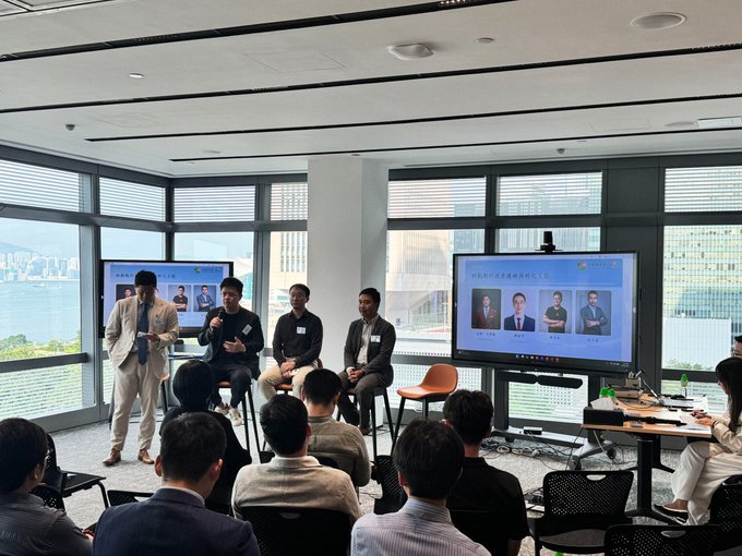 A panel discussion in a modern room with large windows, where four panelists sit in front of a 'CRYPTONEXT' screen while an audience watches.
