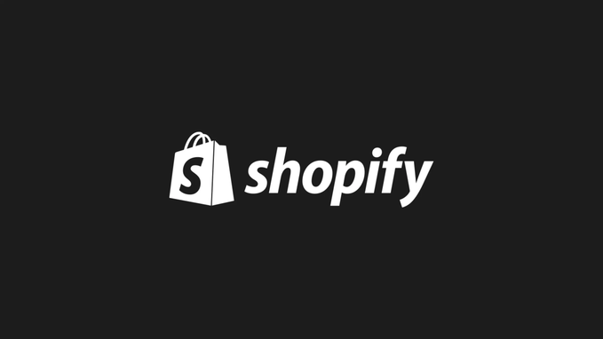 The image features a black background with white text that reads "shopify". The text is capitalized, making it stand out against the dark backdrop. Below this, there's an illustration of a shopping bag, which is also in white color. The image includes a caption that says "Just In: @Shopify will ban all vapes as soon as this week from the platform, after 25 state AGs pushed the e-commerce giant to clamp down on illegal e-cigarettes." This caption provides additional context about the image and its relation to the Shopify logo.