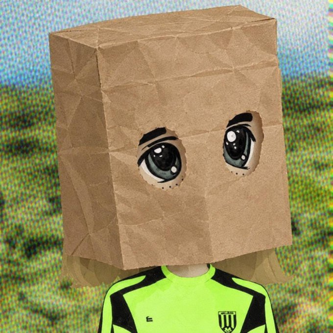 A person wears a brown paper bag over their head with cartoonish eyes cut out, dressed in a neon yellow and black soccer-style jersey with a shield logo. The playful, anonymous image pairs with the "good morning crypto enthusiasts" post as a humorous nod to privacy and the anonymous nature of the crypto community.