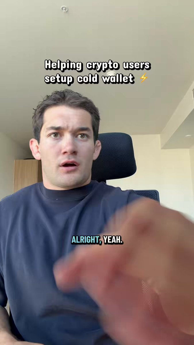 The image shows a man wearing a blue shirt sitting at his desk, with his hand outstretched towards the camera. The caption of the image reads "Love what I do #crypto #cryptoinvest #xrp #xrparmy". This suggests that the man is promoting or discussing something related to cryptocurrency and cold wallets.