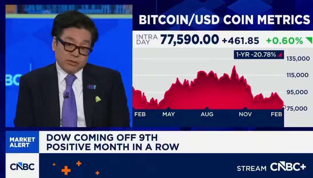 The image shows a man wearing glasses, sitting at a desk with a computer screen displaying a news segment about Bitcoin and cryptocurrency. The news segment features a chart showing the rise of Bitcoin's value over time. The headline reads "BITCOIN/USDCO Coin Metrics", indicating that the segment is discussing the current state of Bitcoin and its impact on the cryptocurrency market.