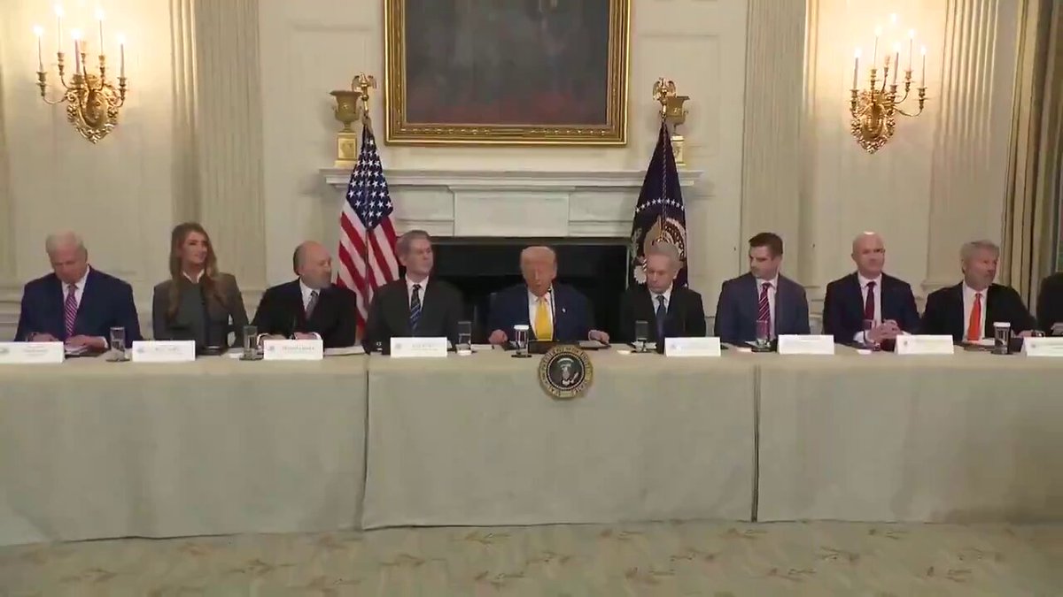 The image shows a group of people sitting at a long table, with one man speaking into a microphone. The setting appears to be a formal event or gathering, possibly related to politics or business. The room has a large painting hanging on the wall behind the attendees and several flags displayed around the space. The post accompanying this image includes text that reads "PRESIDENT TRUMP SAID “I PROMISED TO MAKE AMERICA THE #BITCOIN SUPERPOWER OF THE PLANET AND THE CRYPTO CAPITAL OF THE PLANET." This suggests that the man speaking might be discussing President Trump's plans to create a Bitcoin-like currency, which could potentially revolutionize global financial systems.

The image also features several people sitting at the table, some of whom are wearing ties, indicating a formal or professional setting. The presence of multiple individuals and their attire suggest that this gathering may involve important decision-making or discussions related to politics, business, or other significant matters.